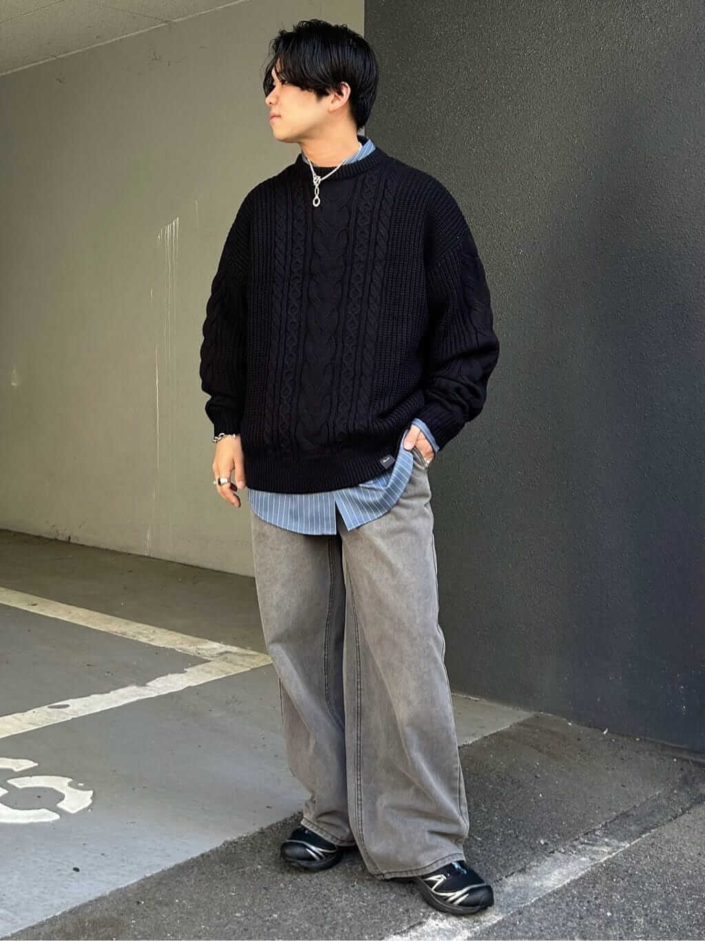 ケーブル編みの黒ニットがアクセントのモノトーンレイヤードコーデ