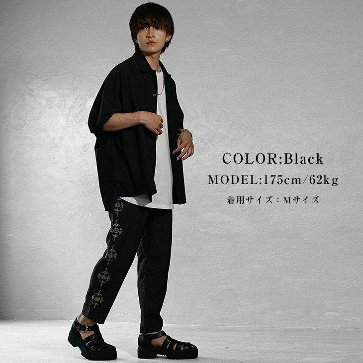 オープンカラー黒シャツとワイドパンツ、グルカサンダルを合わせたストリートスタイル